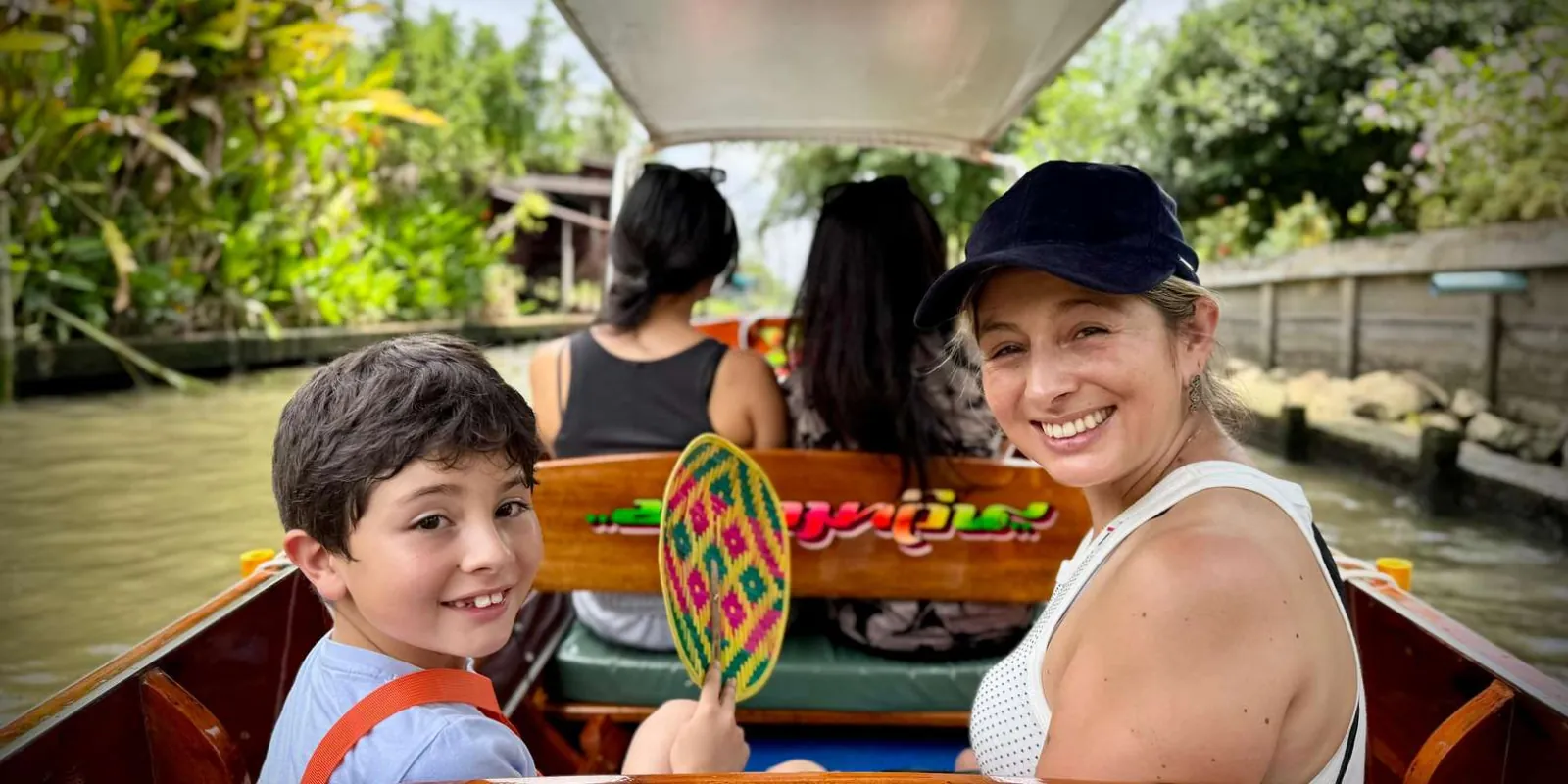 Travelers riding a longtail boat along a canal