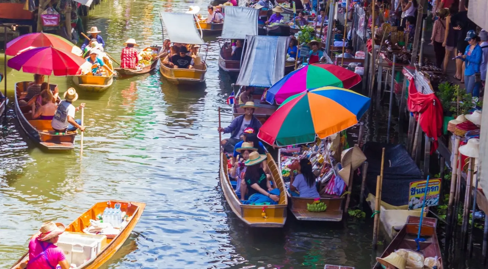 Boats beneath colorful umbrellas on a market canal