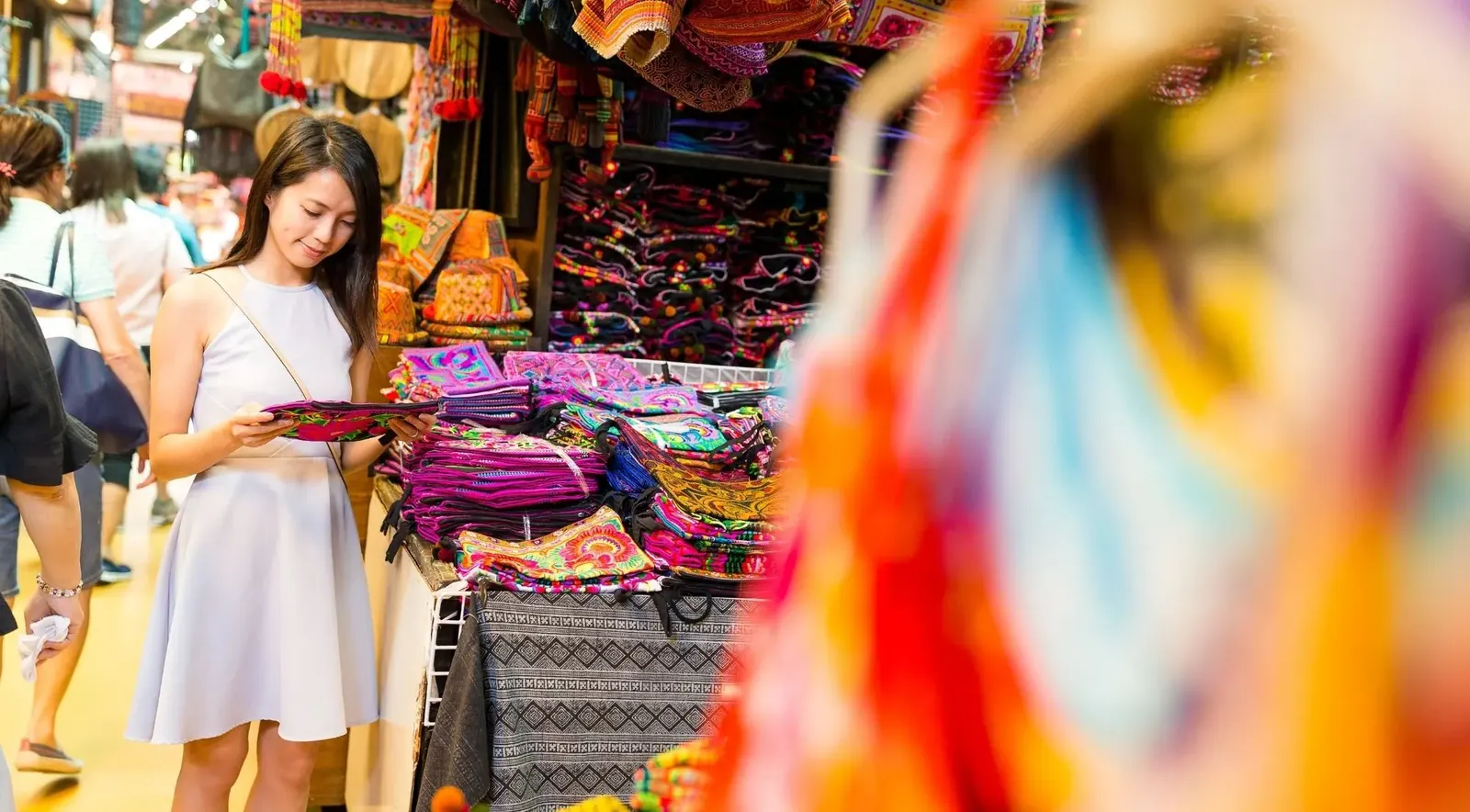 Illustrative market scene with textiles and a shopper